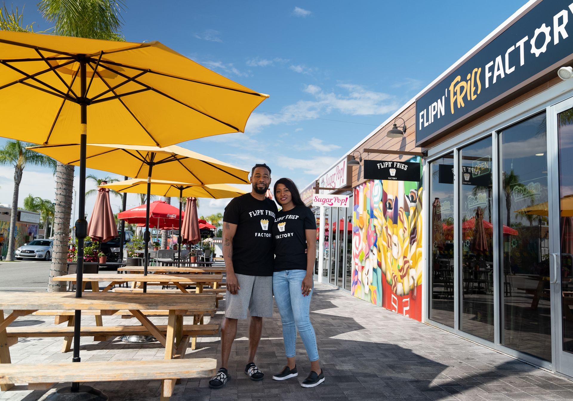 Flipn' Fries Factory owners outside their storefront